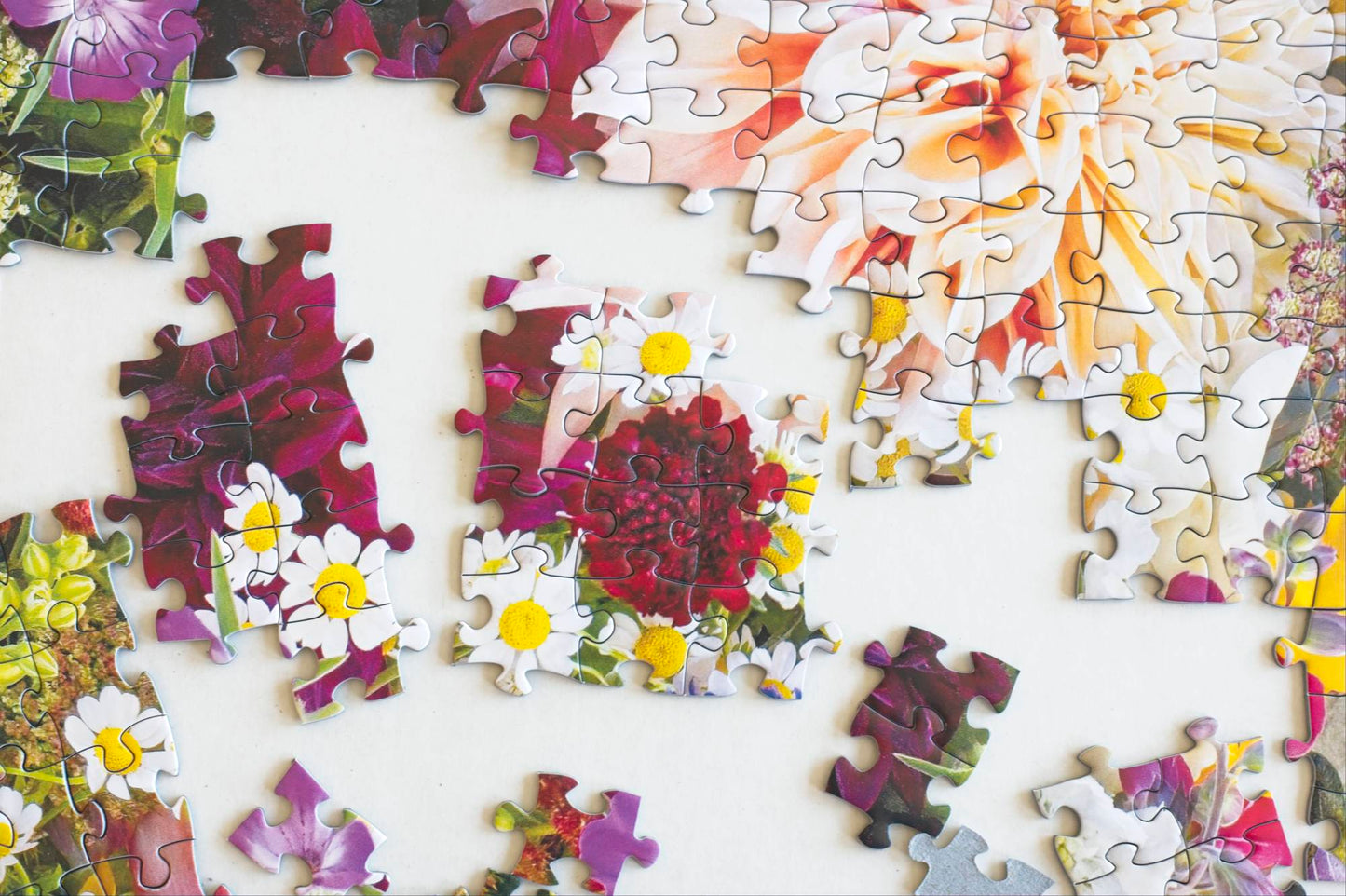 A shot looking straight down on a partial puzzle featuring a photo of a colorful floral arrangement
