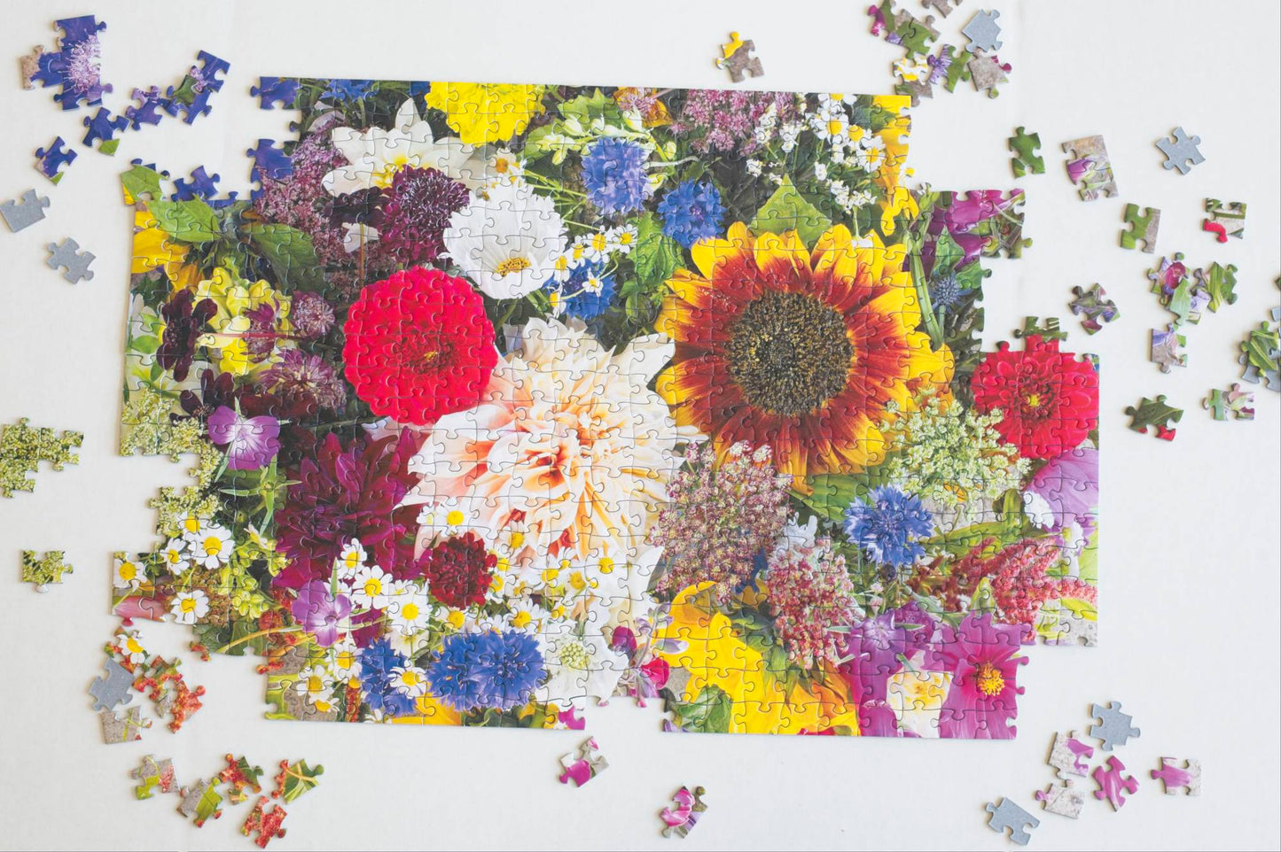 A partially completed jigsaw puzzle with a colorful floral design on a white background