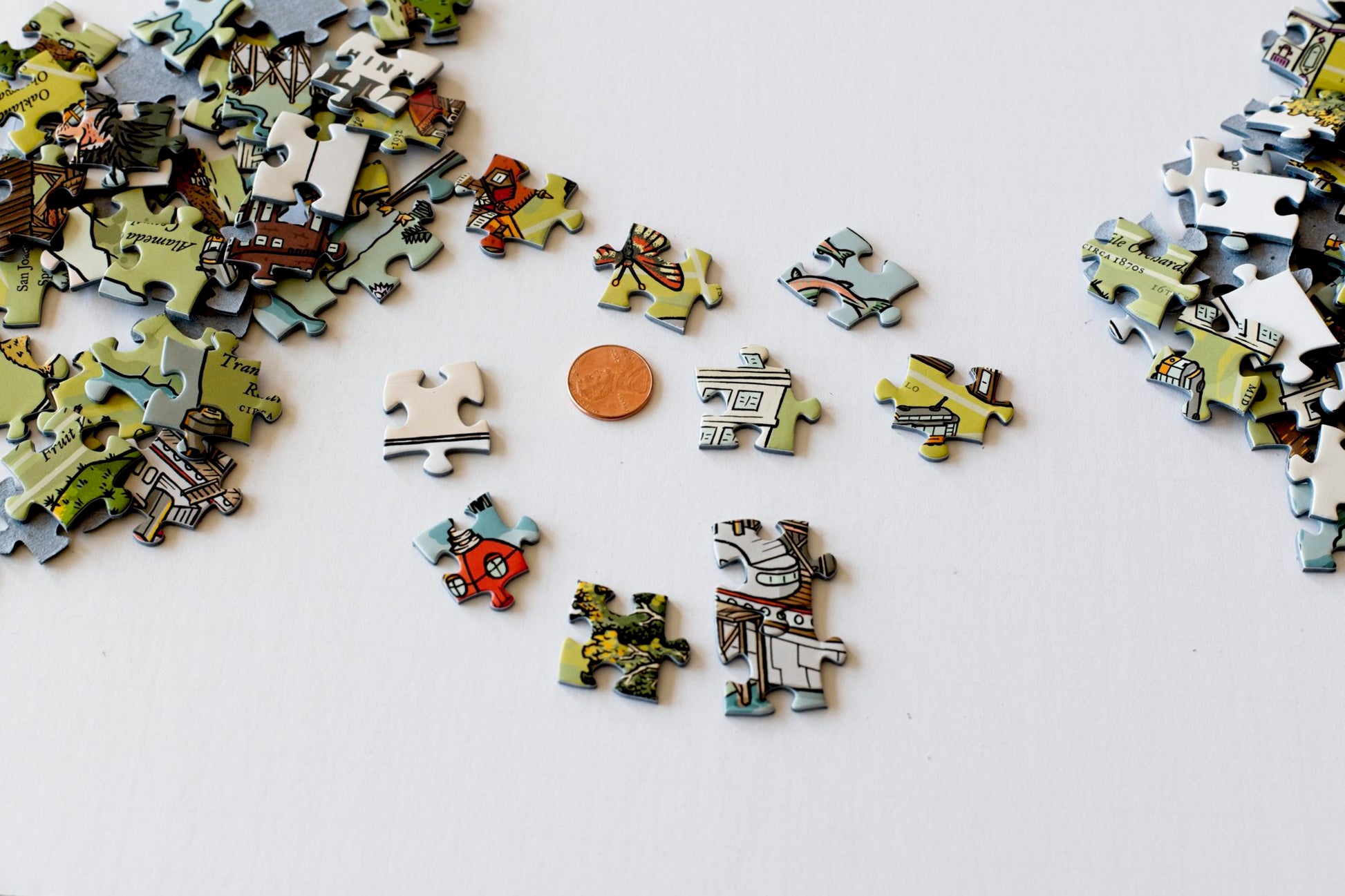 Colorful puzzle pieces scattered around a penny to show that the pieces are aslightly larger size.