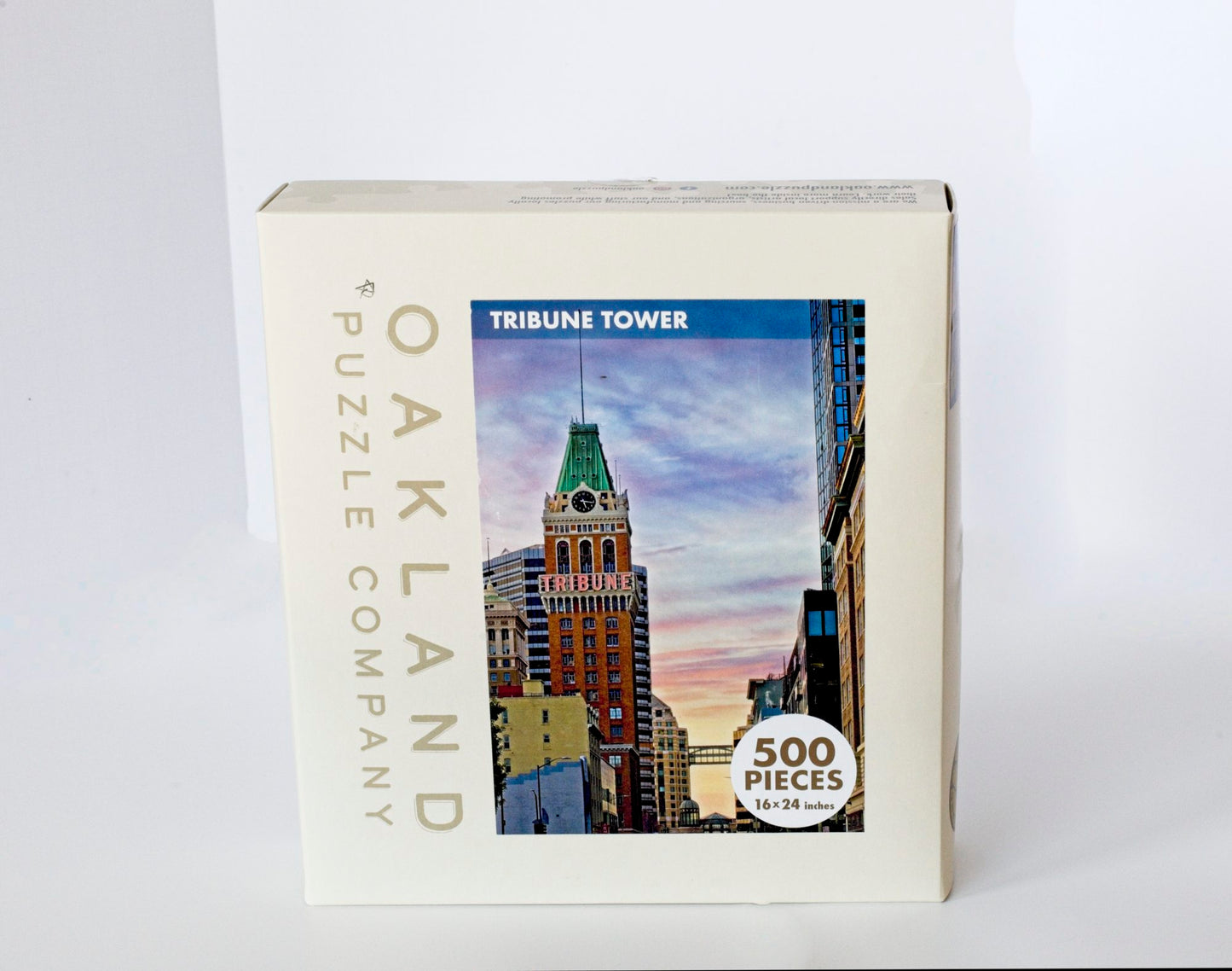 A box branded Oakland Puzzle Company featuring the Tribune Tower puzzle image on the front.