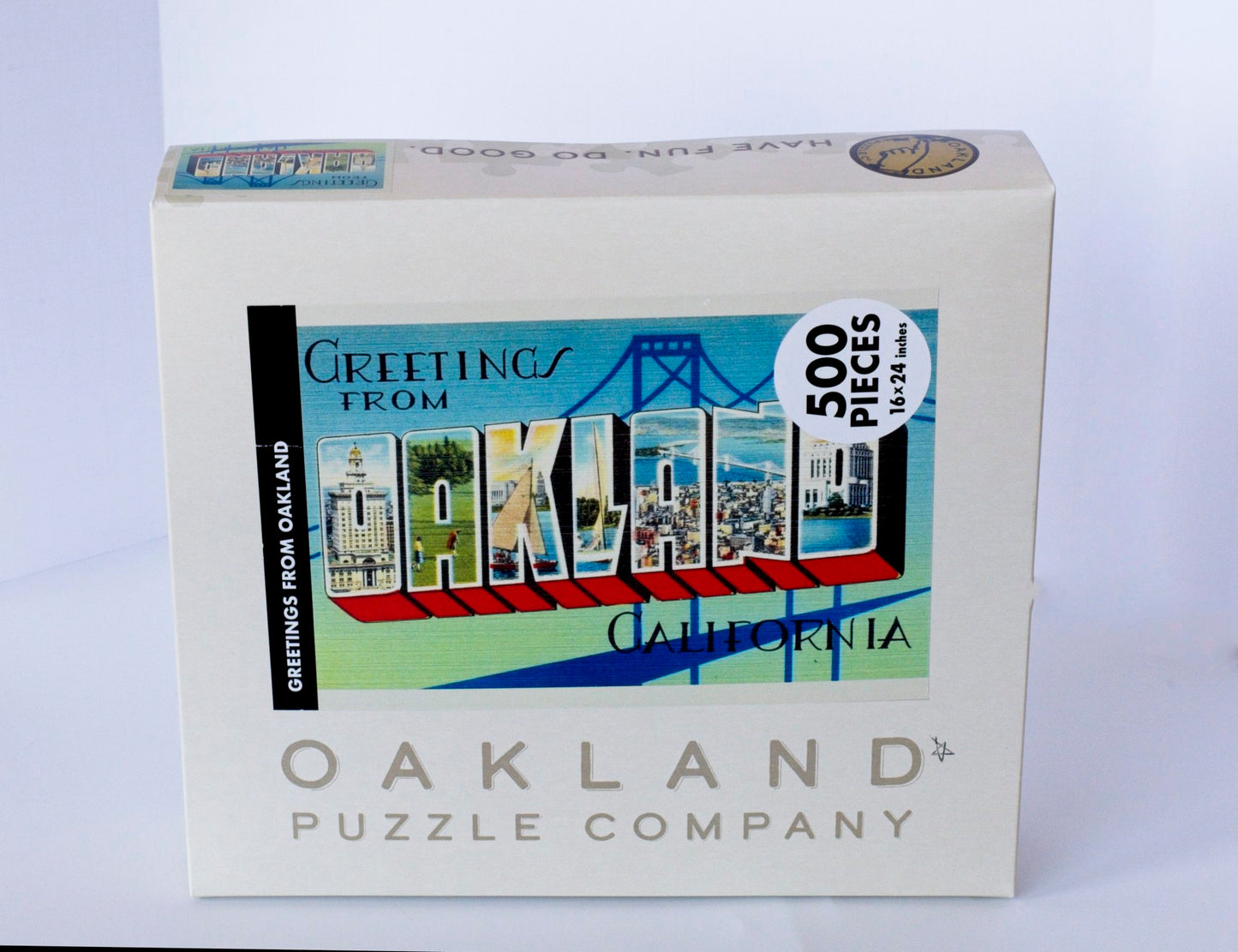 A box branded Oakland Puzzle Company with the Greetings from Oakland image featured on the front.