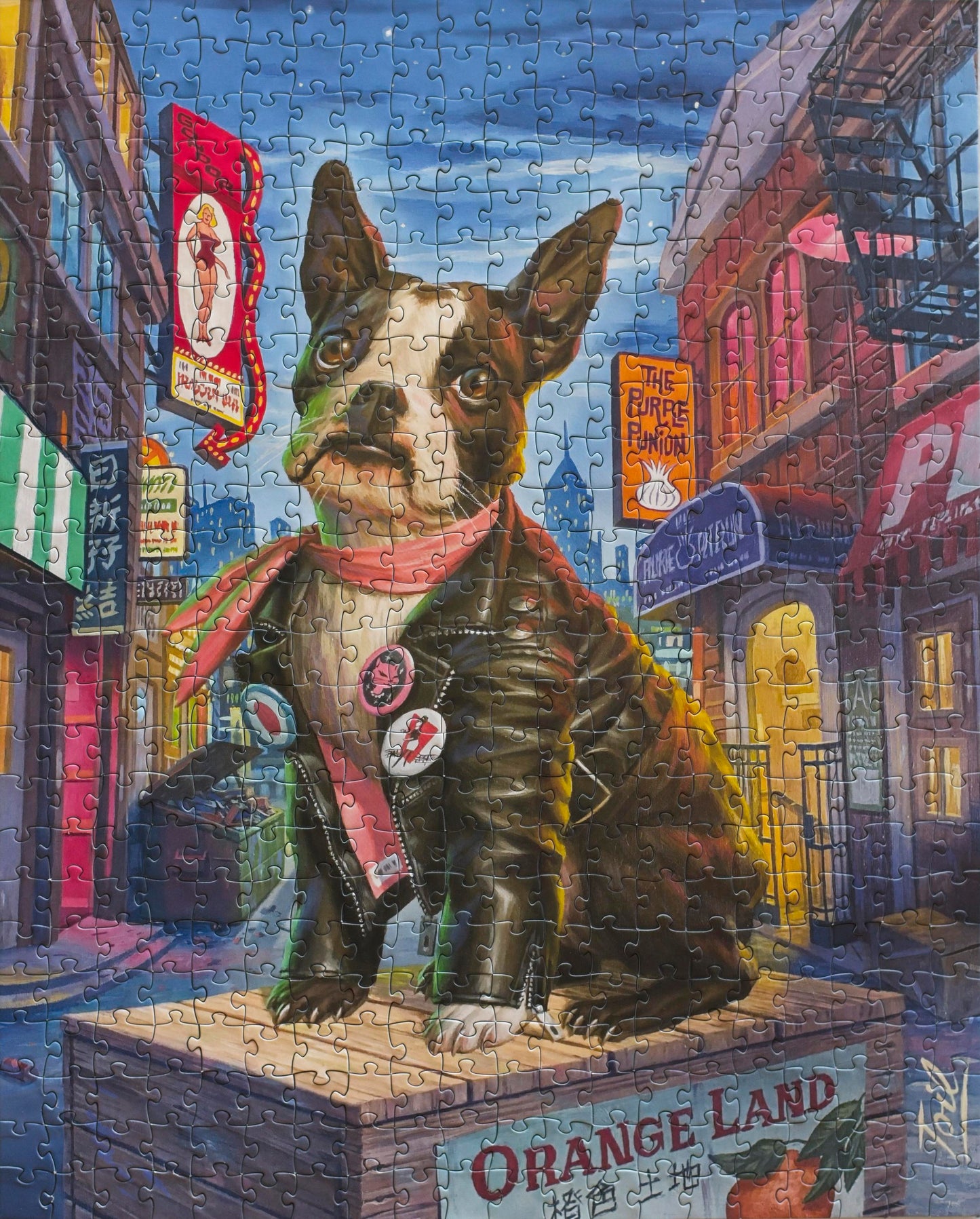 A completed jigsaw puzzle of a painting of a large-eyed Boston Terrier wearing a leather jacket and scarf, and sitting on an orange crate surrounded by landmarks in the North Beach neighborhood of San Francisco.