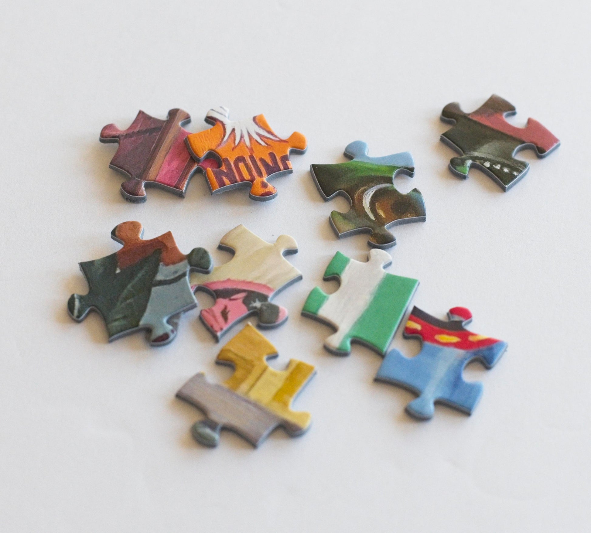 Nine brightly colored puzzle pieces scattered.