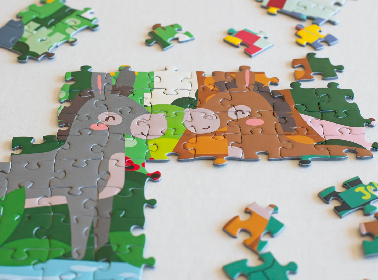 A close-up of joined jigsaw puzzle pieces that show two illustrated donkeys nose to nose.