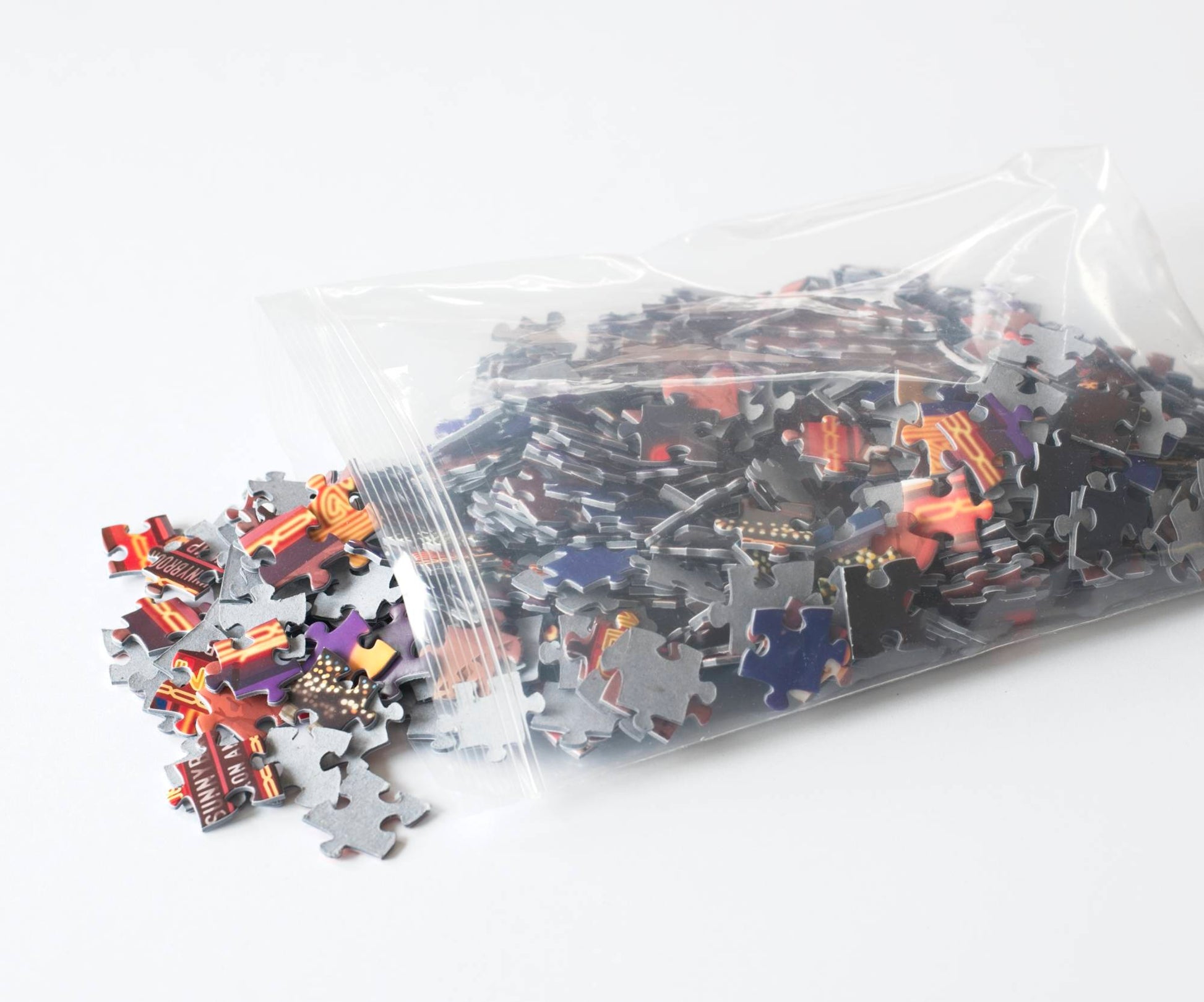 A photo of brightly colored puzzle pieces spilling from a high-quality resealable plastic bag.