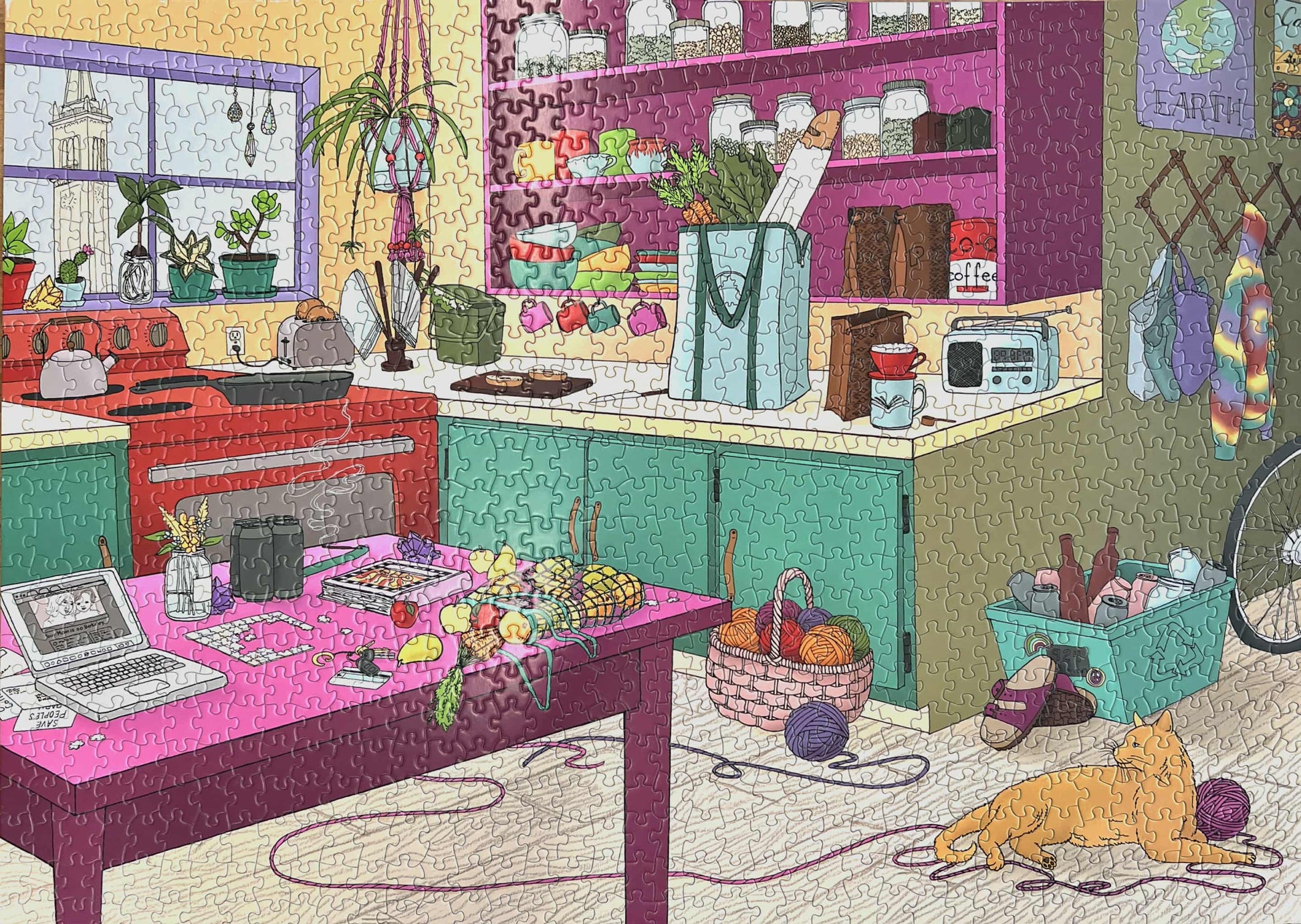 A completed jigsaw puzzle featuring a colorful kitchen scene with a cat, laptop, and various items on a table.
