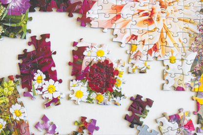 A shot looking straight down on a partial puzzle  featuring a photo of a colorful floral arrangement