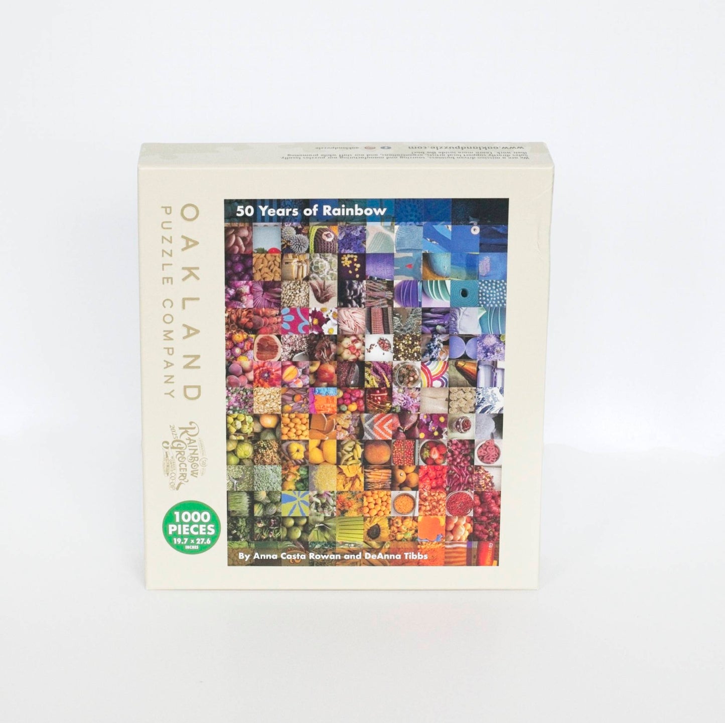 A photo of a beige product box branded Oakland Puzzle Company and Rainbow Grocery with text reading 50 Years of Rainbow by Anna Costa Rowan and DeAnna Tibbs, 1000 pieces 19.7x27.6 inches