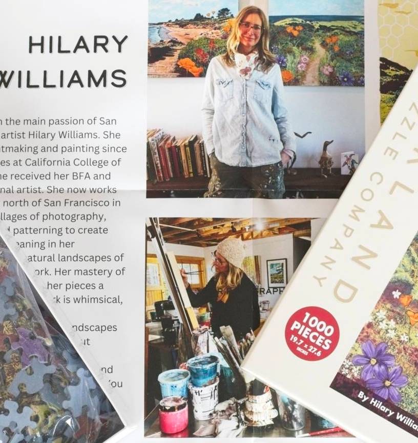 An open puzzle box with a poster featuring text and photos of artist Hilary Williams in her studio.