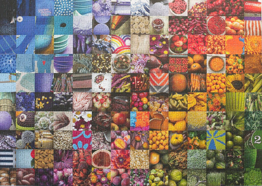 A photo of a completed traditionally cut jigsaw puzzle featuring a collage of 140 photos in a grid arranged roughly in a rainbow showing fruits, vegetables, flowers, textiles, and other goods commonly found in grocery stores.