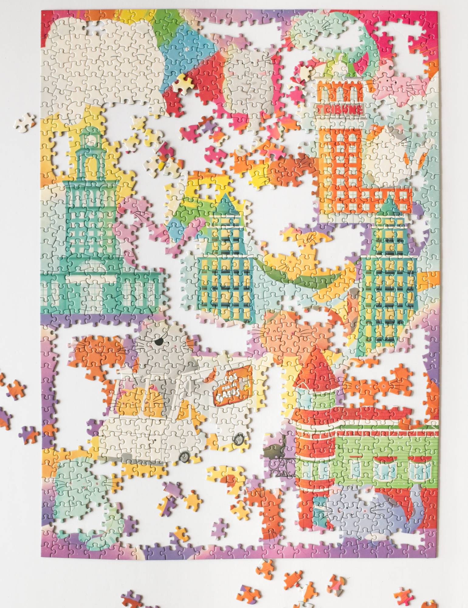 A partially completed jigsaw puzzle with cartoon cats and buildings on a white puzzle board