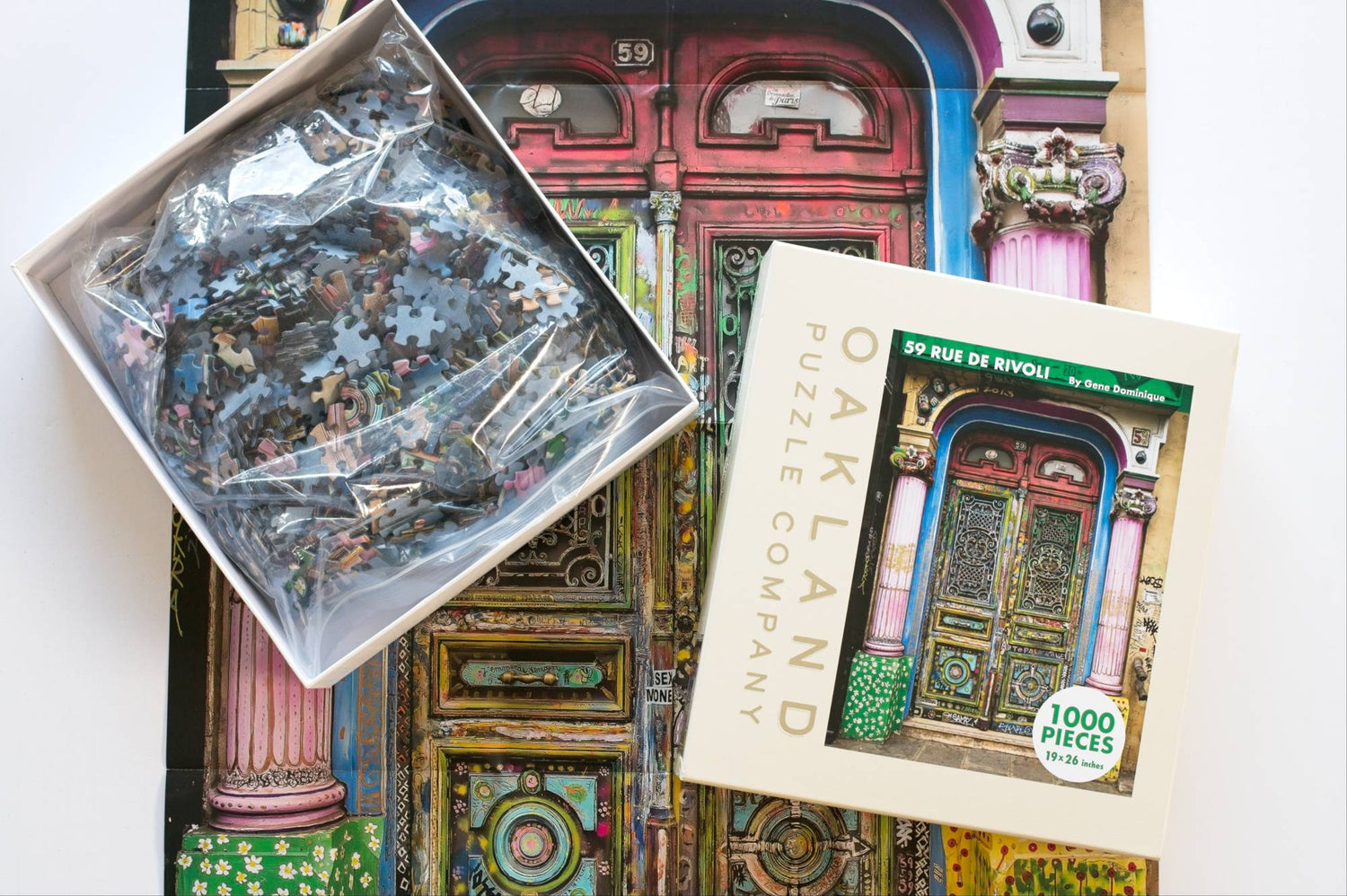 A jigsaw puzzle box open on a reference poster of a colorful doorway. The bottom of the box shows a resealable plastic bag filled with pieces the top has Oakland Puzzle Company.