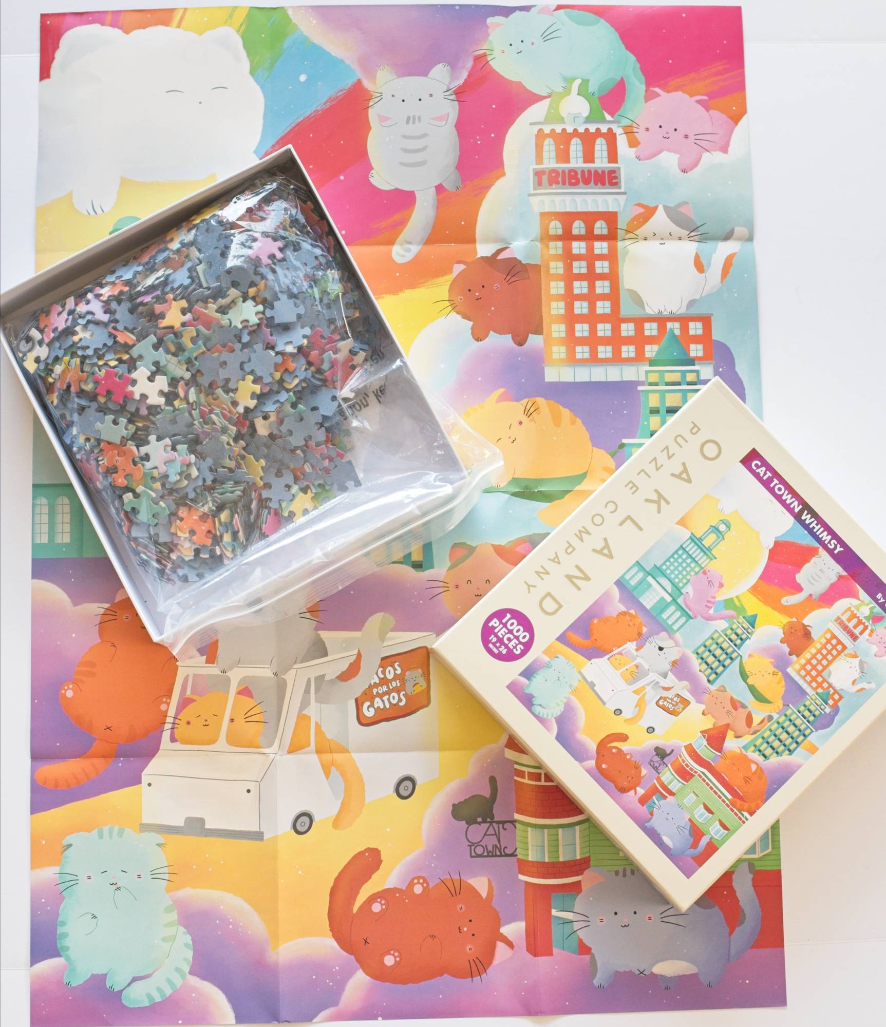 Jigsaw puzzle set with colorful packaging featuring cartoon cats and a building.