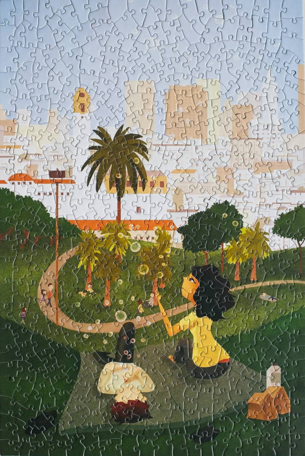 A completed random-cut jigsaw puzzle with a scene of two people blowing bubbles in a park.