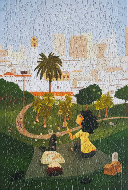 A completed random-cut jigsaw puzzle with a scene of two people blowing bubbles in a park.