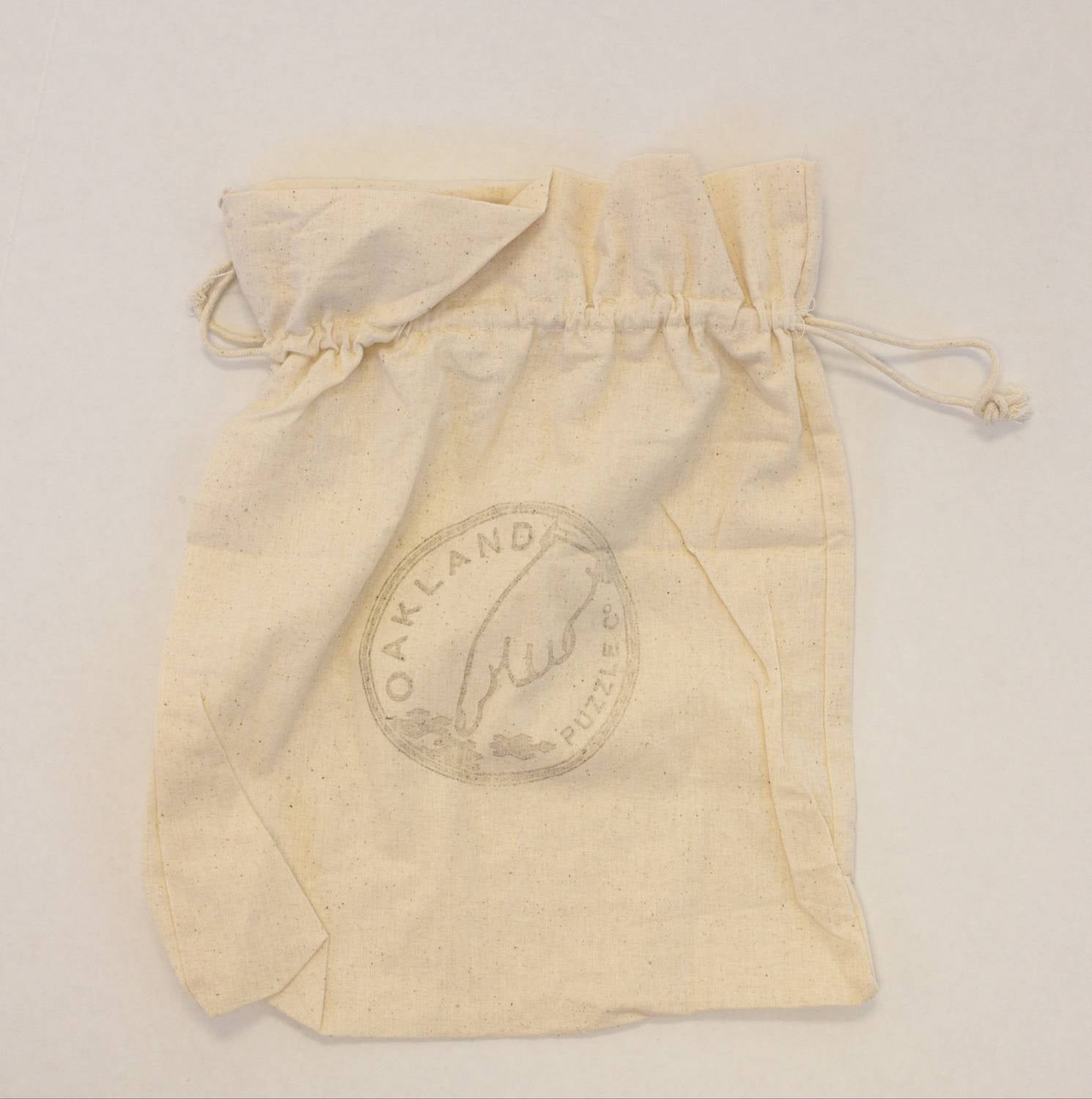 Beige drawstring bag with a circular logo on a light gray background