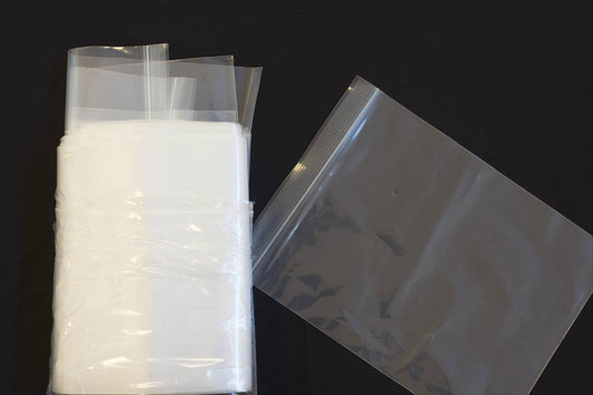 A group of resealable bags next to a single resealable bag on a black background
