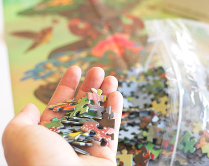Hand holding a puzzle piece with a colorful reference image in the background