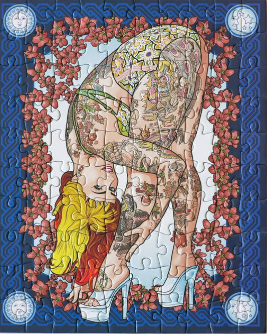 A completed jigsaw puzzle featuring a stylized illustration of a tattooed woman in a yellow and green bodysuit, bending forward while wearing white high heels. The artwork is framed by pink flowers on a blue patterned border, with circular decorative elements in the corners.