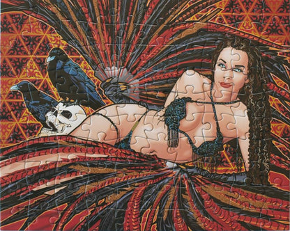 A completed jigsaw puzzle featuring a stylized illustration of a reclining woman with long dark hair, wearing a black fringed bra and matching skirt, posed with two black crows and a white skull against a red, orange, and black patterned background.