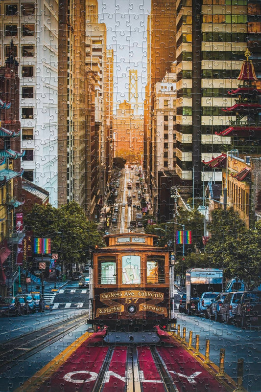 A completed jigsaw puzzle of a photograph of a trolley coming up a San Francisco hill toward the viewer with the sunrise and a bridge in the background