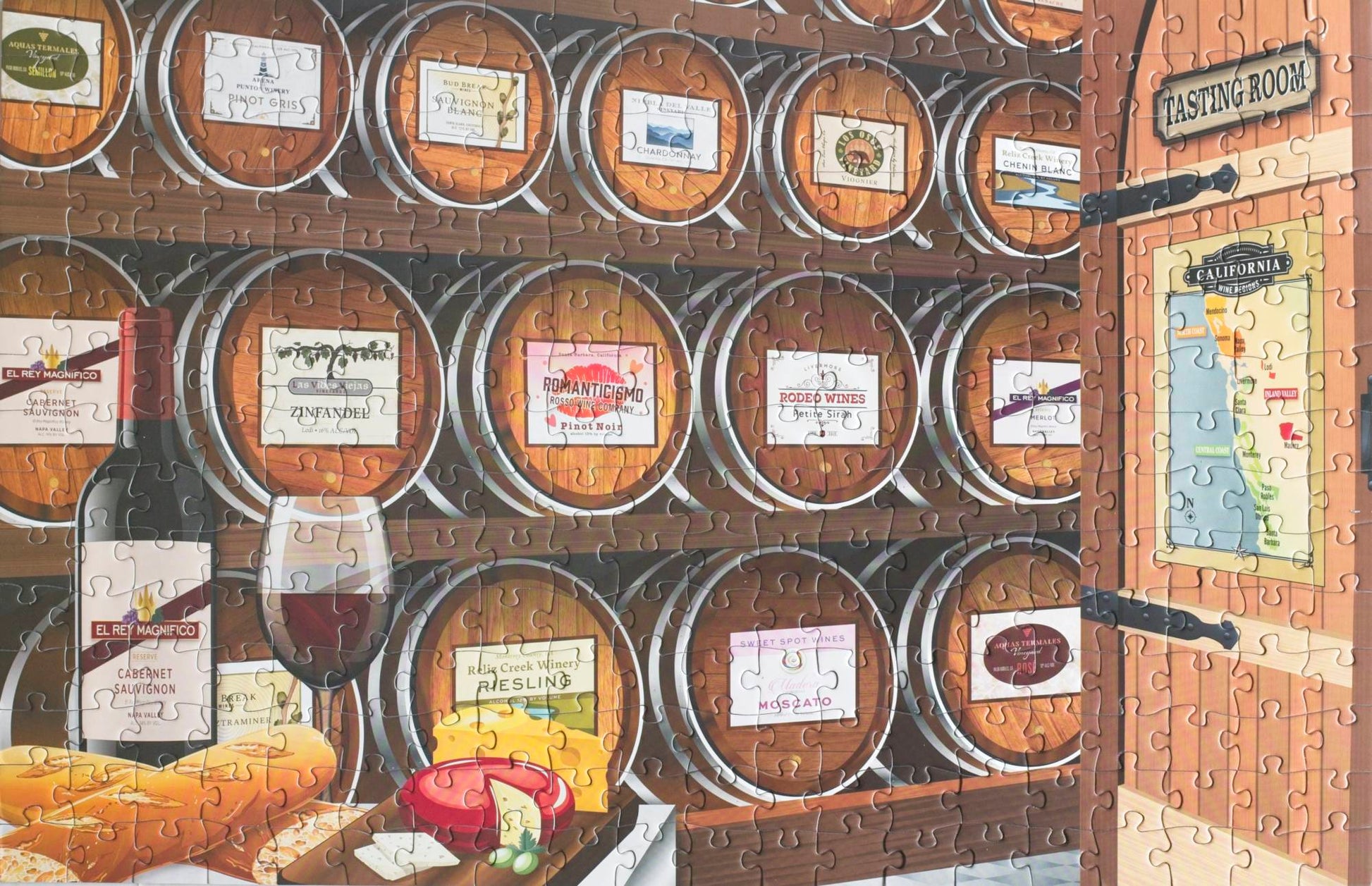 A completed jigsaw puzzle that is a designed rendering of a wine tasting room showing a cheese plate, wine glass and bottle, and barrels with wine lables. The door features a map of California with wine regions marked