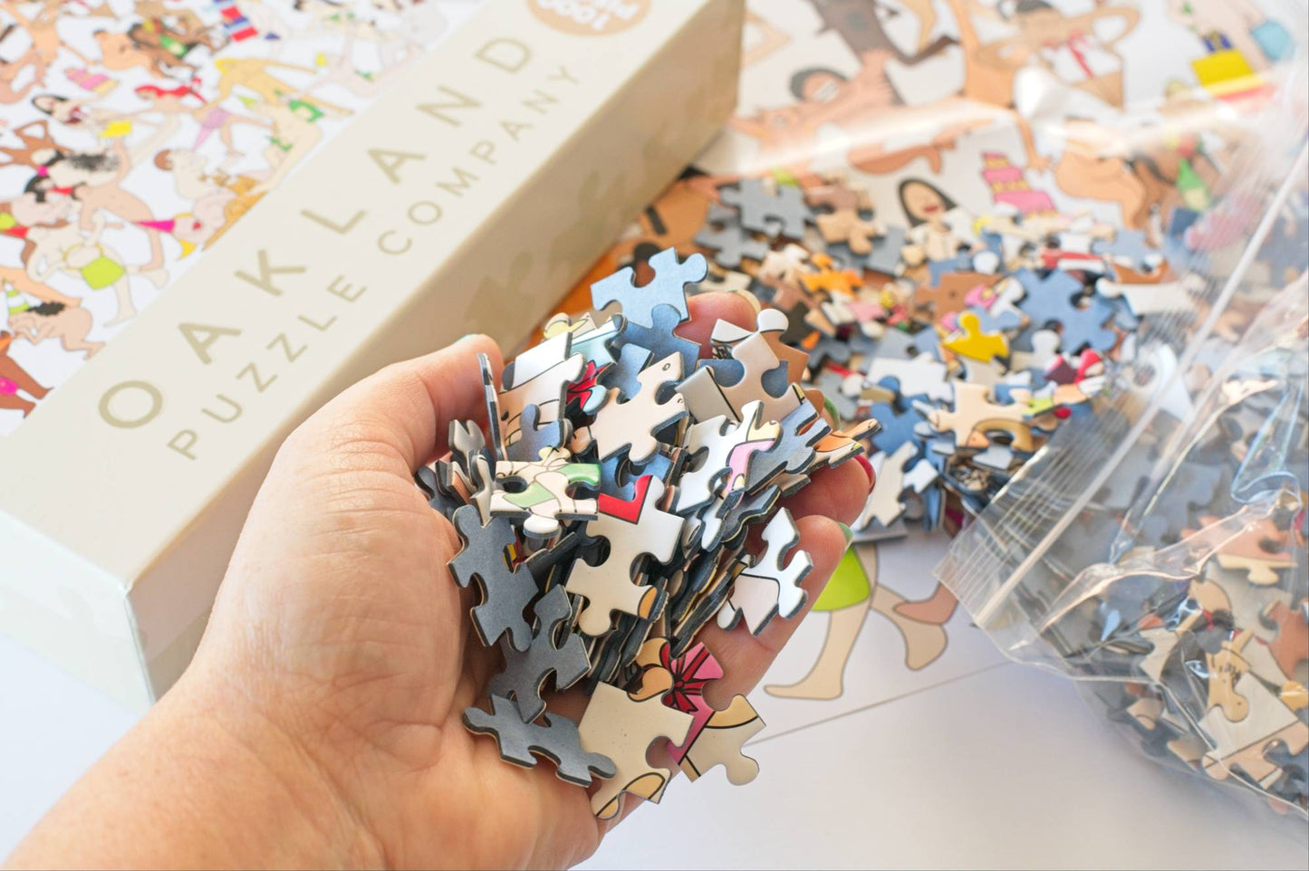 Hand holding puzzle pieces with a  packaging in the background