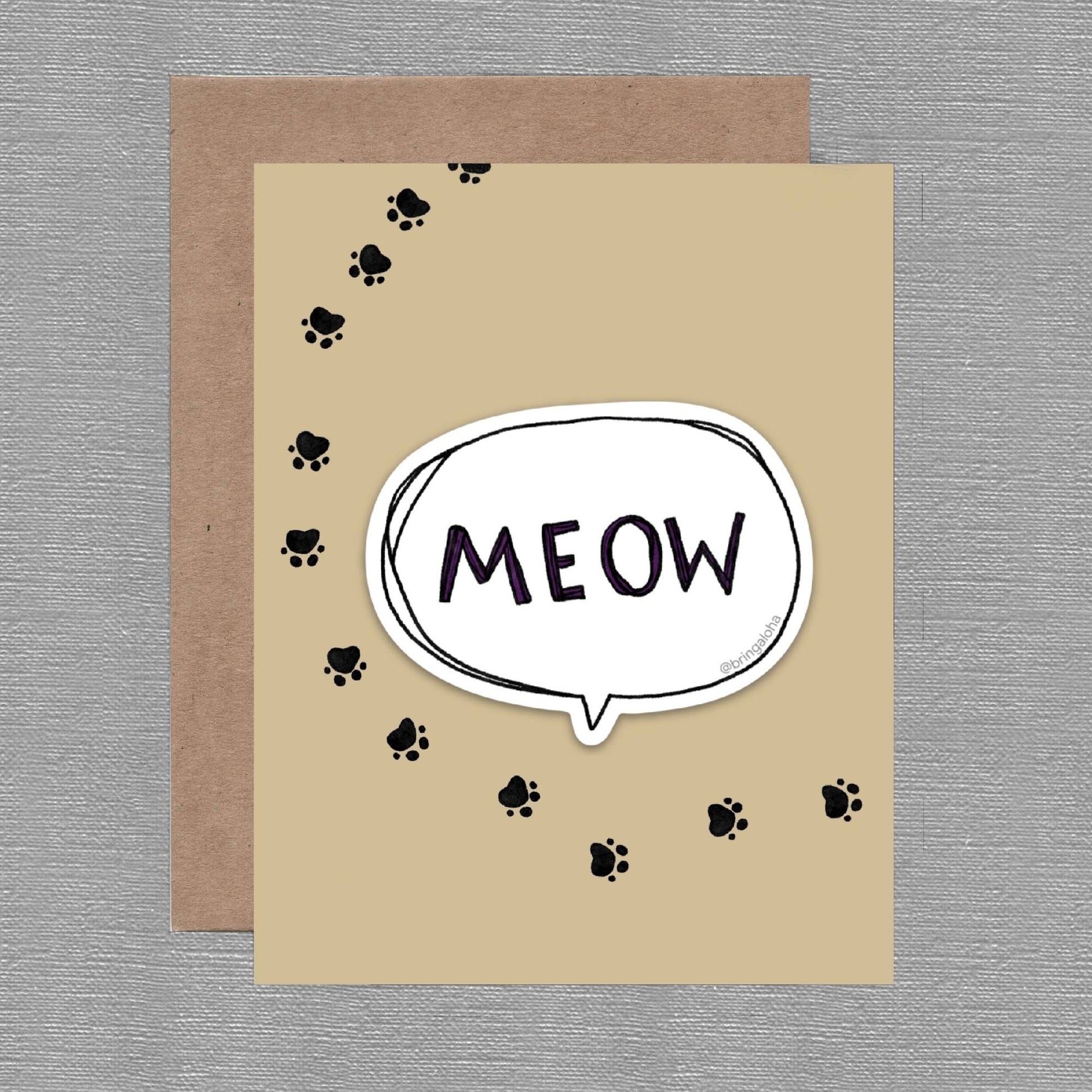 Card with 'MEOW' text in a speech bubble and paw prints on a brown background