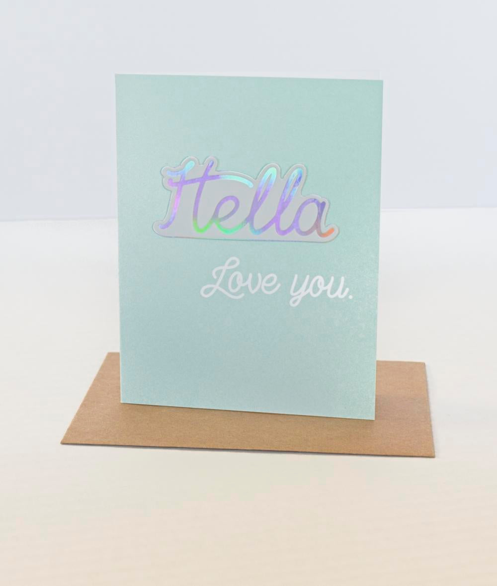 A sticker card with the name 'Stella' written on it, placed on a brown envelope, with a white background.