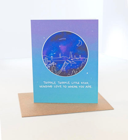 Blue greeting Card with a dark blue sticker with a whimsical doodle of a an evening scene of the Bay Bridge Leading to San Francisco with the text Twinkle Twinkle Little Star, Sending love to where you are.