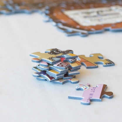  stack of colorful jigsaw puzzle pieces with a partially completed puzzle in the background