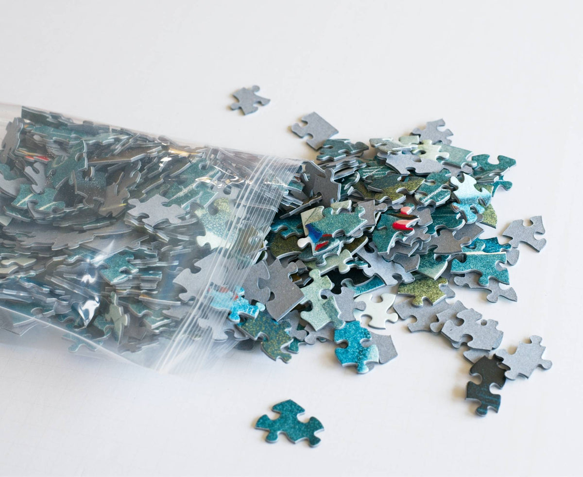 A resealable plastic bag spilling out puzzle pieces