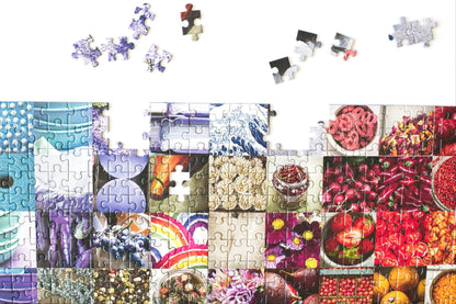 A top section of a nearly complete jigsaw puzzle with a few pieces scattered above. The puzzle has photos of colorful geometric patterns and items in a grid pattern.