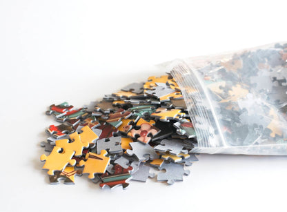 Colorful puzzle pieces scattering out of a resealable plastic bag onto a white surface.