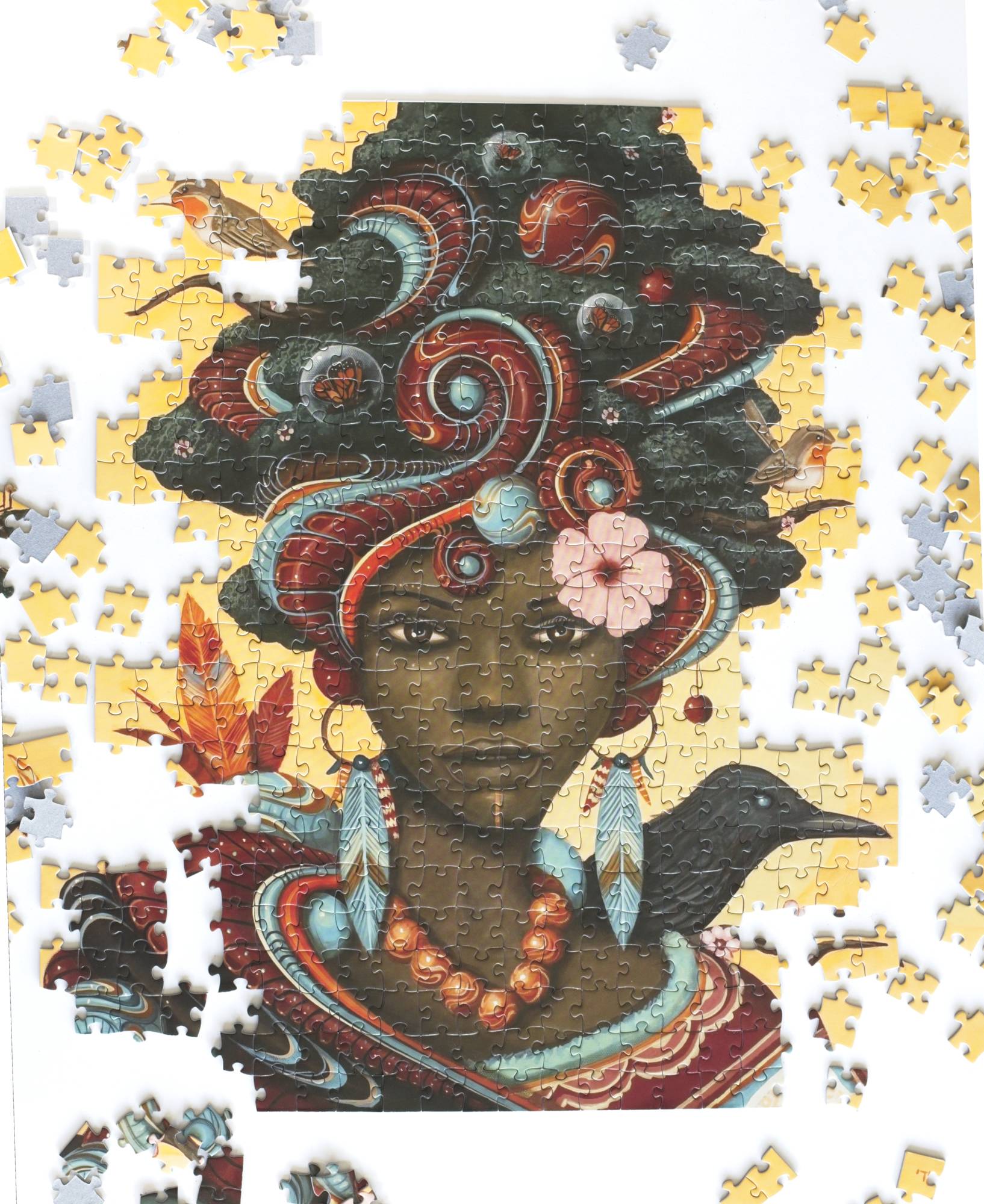 Partially completed colorful puzzle made on blue board with an African woman's face with scattered puzzle pieces