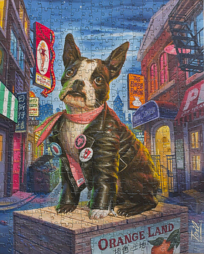 A completed jigsaw puzzle of a painting of a large-eyed Boston Terrier wearing a leather jacket and scarf, and sitting on an orange crate surrounded by landmarks in the North Beach neighborhood of San Francisco.