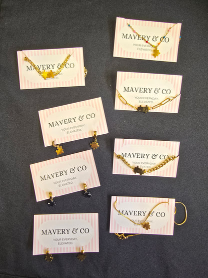 Jewelry display with 'MAVERY & CO' on cards against a dark background