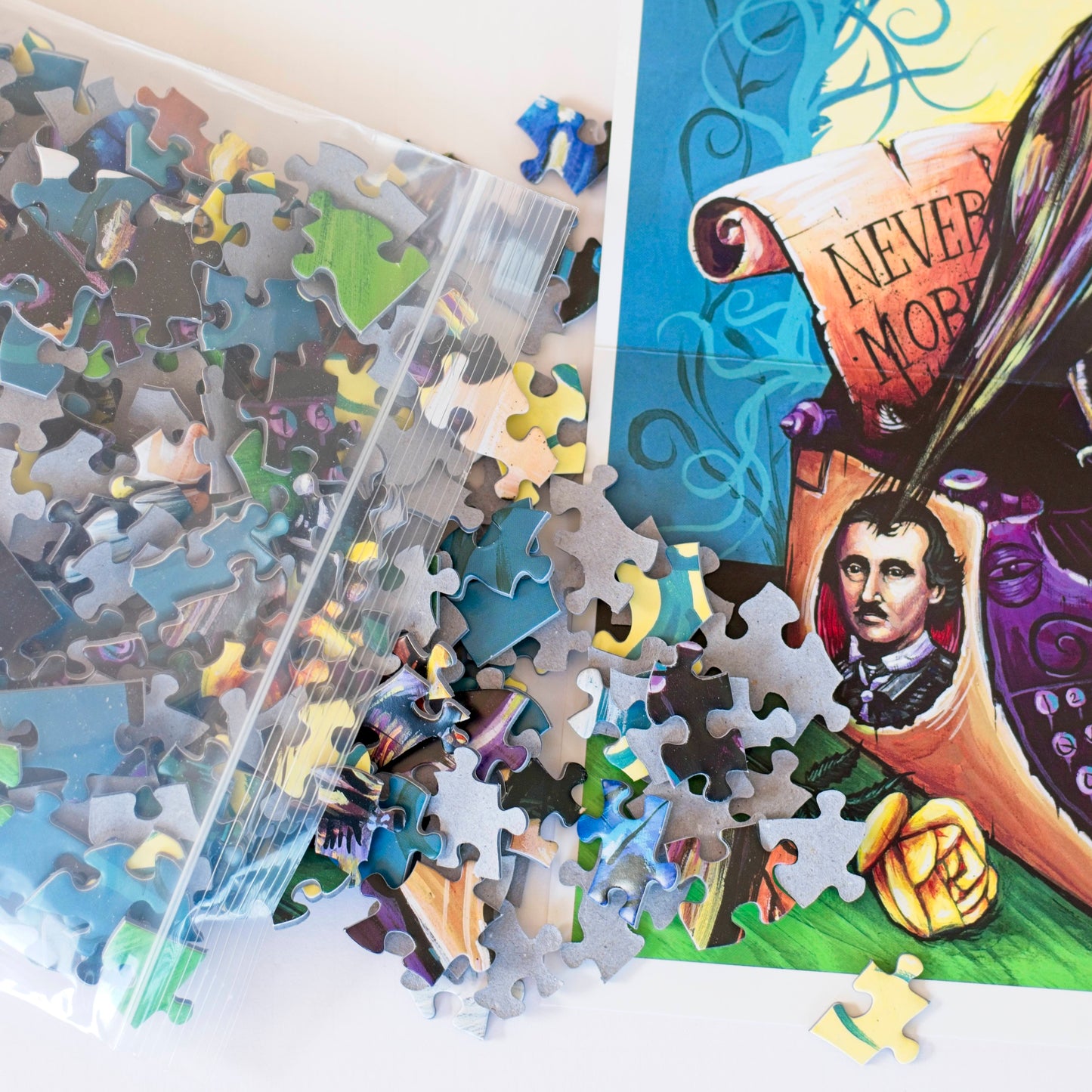 Close up photo of puzzle pieces spilling out of a plastic bag onto the corner of the Raven Never More poster.