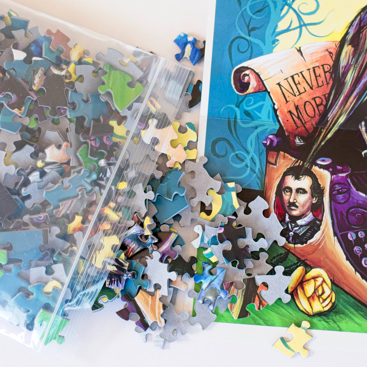 Close up photo of puzzle pieces spilling out of a plastic bag onto the corner of the Raven Never More poster.