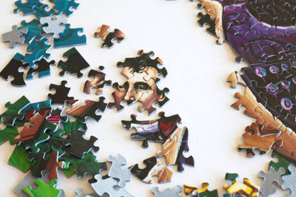 Jigsaw puzzle with a partially completed portrait and typewriter on a white background