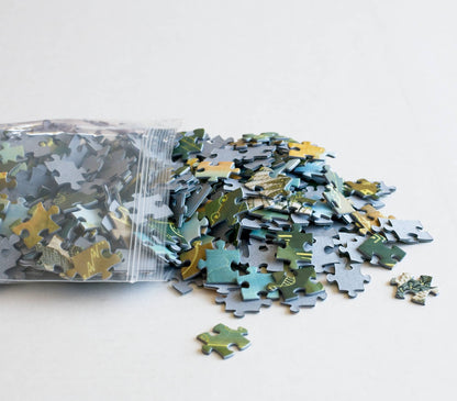 A resealable bag spilling out a pile of puzzle pieces on a white background
