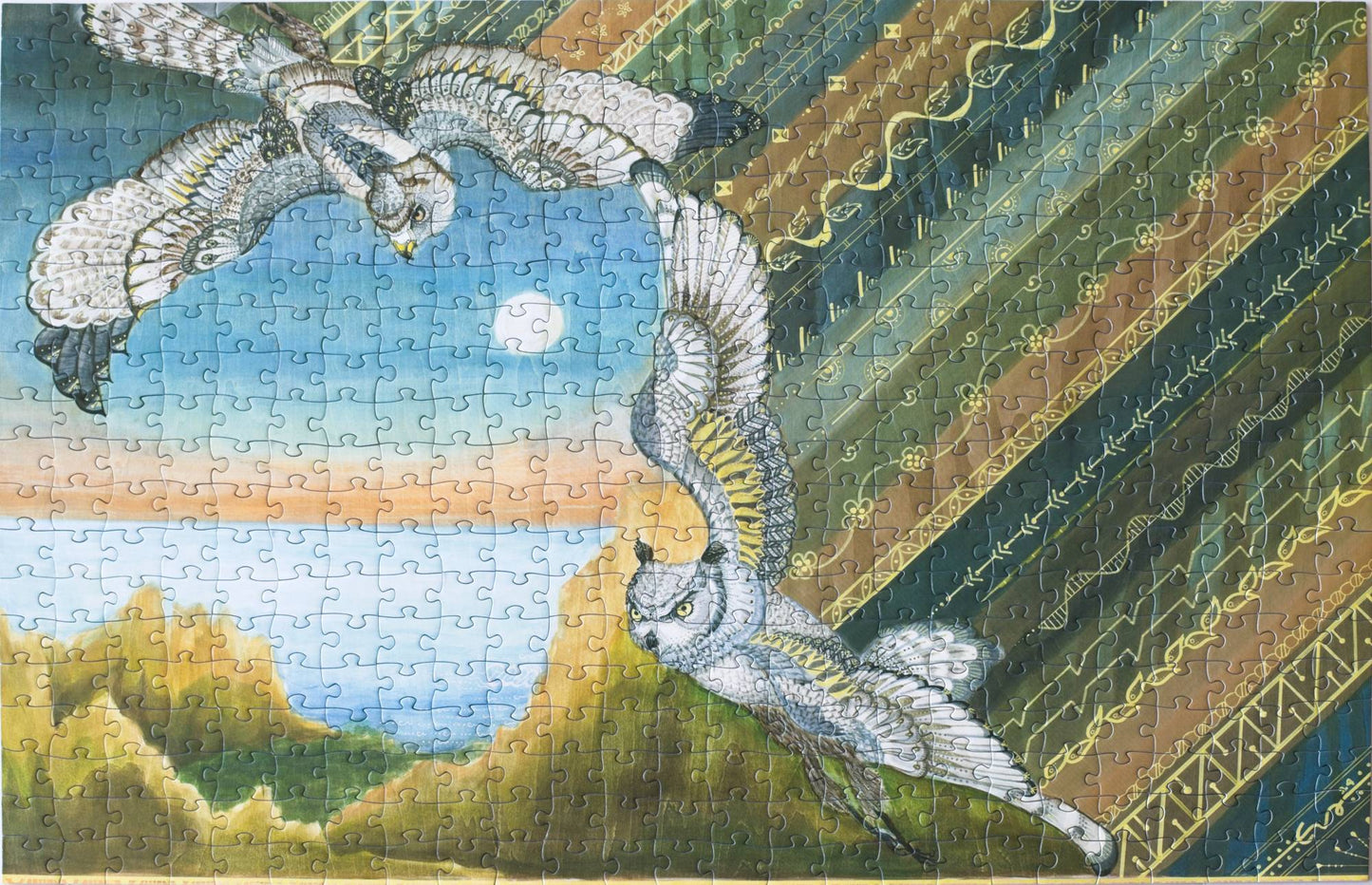 A photo of a completed jigsaw puzzle featuring two raptors and a rugged coastline with a batik pattern on one side.