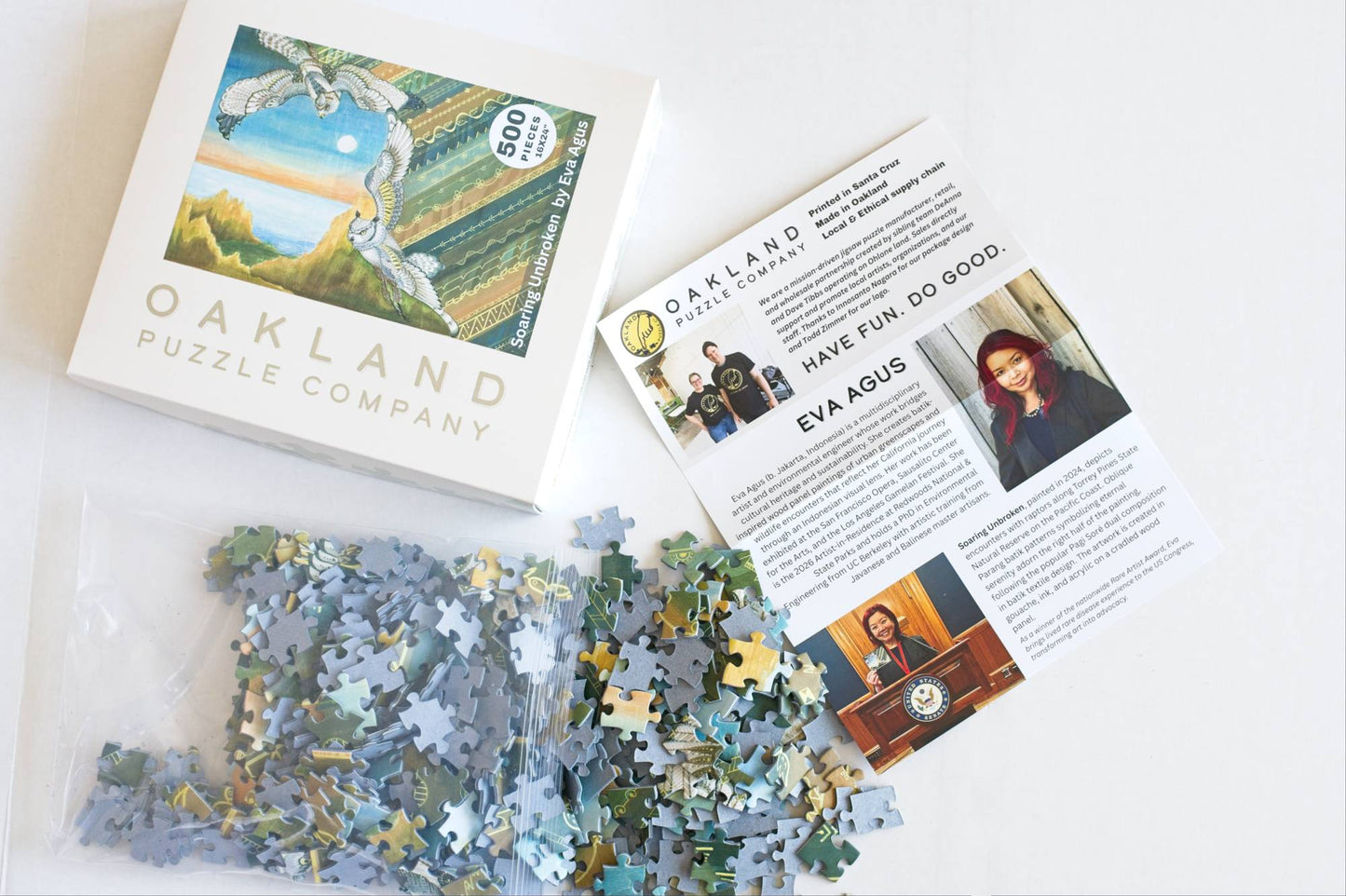 Oakland Puzzle Company packaging with puzzle pieces and an artist bio on a white background