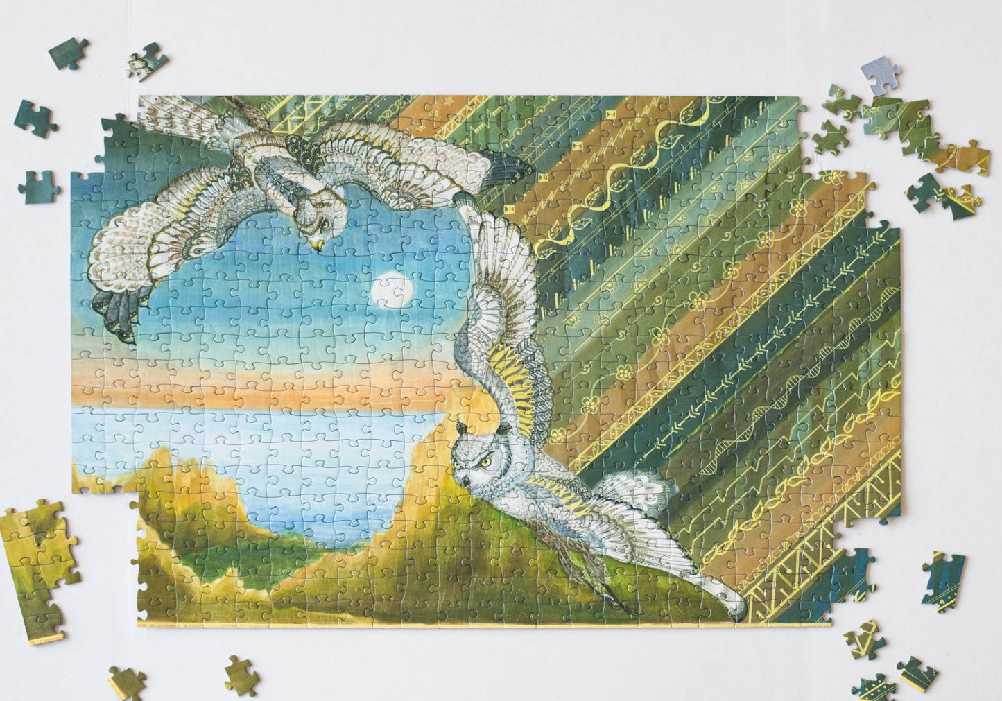 Jigsaw puzzle close to completion showing a landscape with birds and geometric patterns.