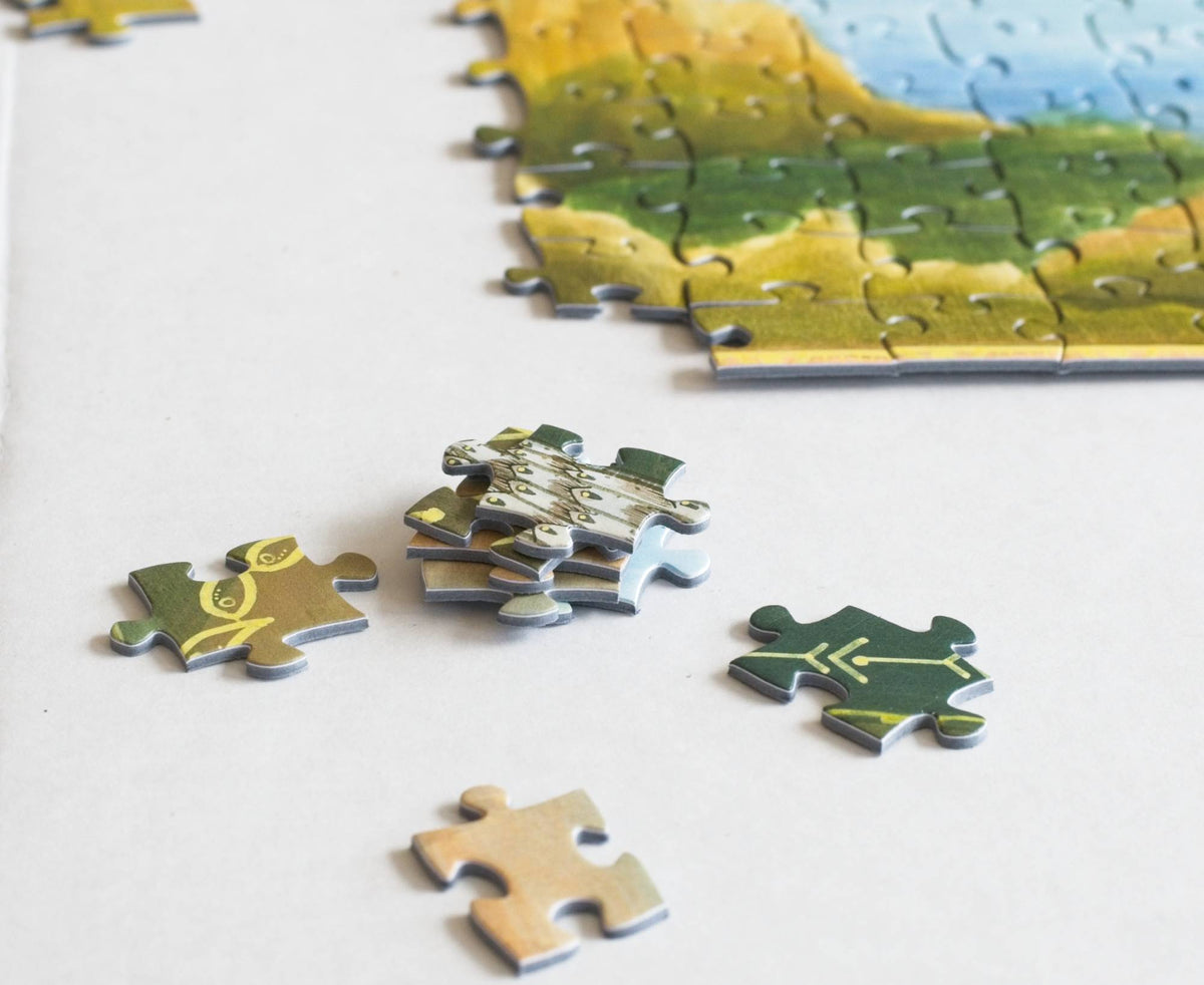 Jigsaw puzzle pieces on a white surface with a partially completed puzzle.
