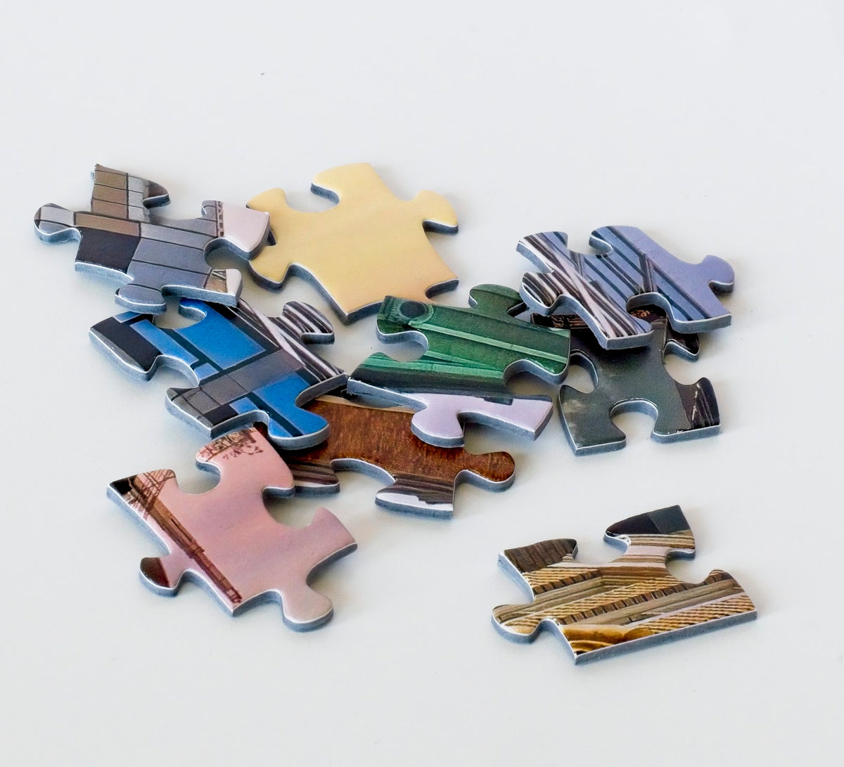 A close up photo of a colorful variety of loosely stacked jigsaw puzzle pieces. 
