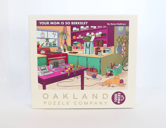 A box branded Oakland Puzzle Company with an illustrated image titled 'Your Mom is So Berkeley' by Dawn Kathryn, featuring a colorful and busy kitchen scene, on a white background